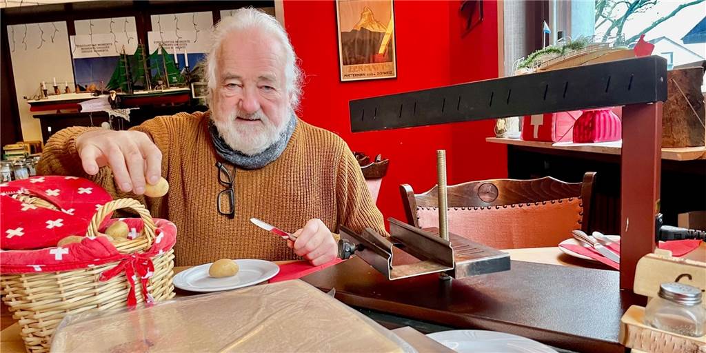 Schweizer Raclette zu Weihnachten oder zu Silvester: Die Bootschaft macht’s vor Lothar Preukschat in seiner Schweizer Bootschaft: Rechts der Raclette-Ofen, den man auch ausleihen kann, links ein frischer Raclette-Käse aus der Schweiz.