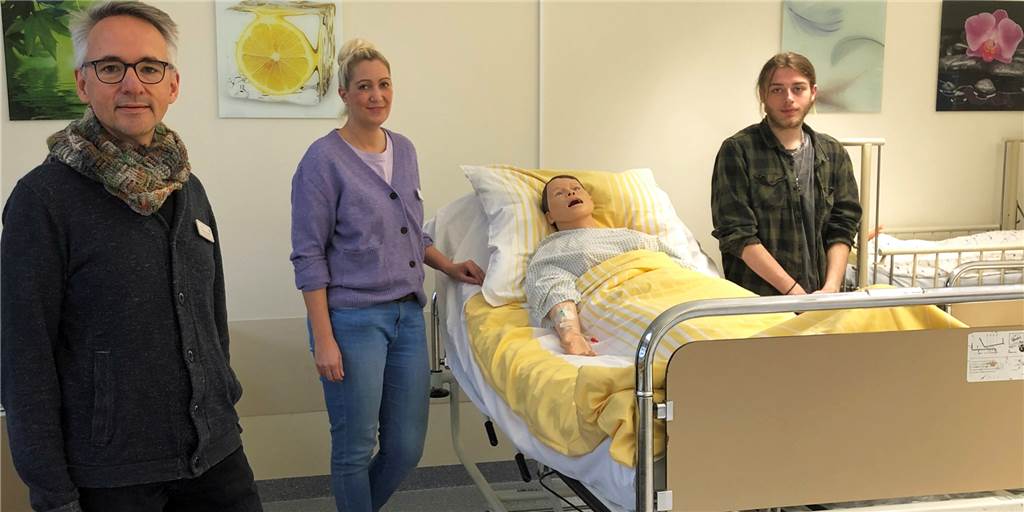 Pflegefachschule meldet starke Nachfrage: Schüler sind „Helden in Ausbildung“ Schulleiter Martin Hückelheim, Lehrerin Dorothee Willmes und Pflegefachschüler Paul Bühner (v.l.) im Praxisraum der Pflegefachschule: