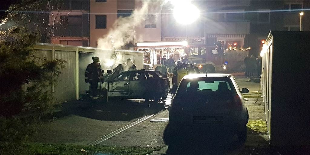 Flammen in Garagenhof: Polizei stellt Fahrzeugwrack sicher Nach den Löscharbeiten zog die Feuerwehr das Fahrzeug aus der Garage, um alle Glutnester erreichen zu können.