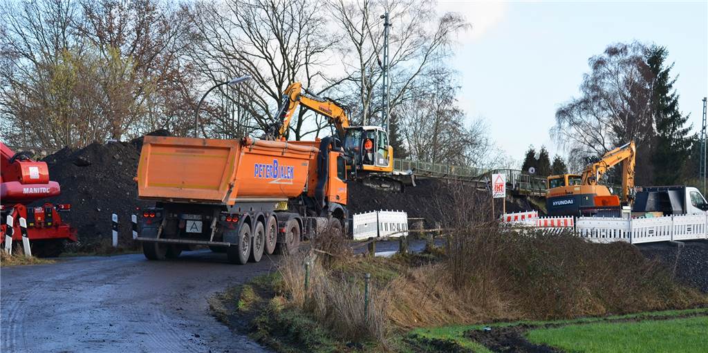 Straßensperrung: Radfahrer fahren Umwege wegen Arbeiten an einer Bahnbrücke Bagger bereiten eine größere Baumaßnahme für das Wochenende von 7. bis 10. Januar vor. Muldenkipper transportieren Erdreich und Schotter ab.