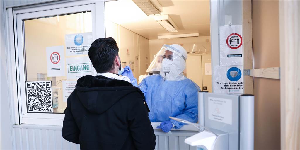 RKI meldet für Dortmund die zweitmeisten Corona-Neuinfektionen pro Tag Eine Mitarbeiterin macht einen Corona-Schnelltest bei einem Mann an einer Teststation.