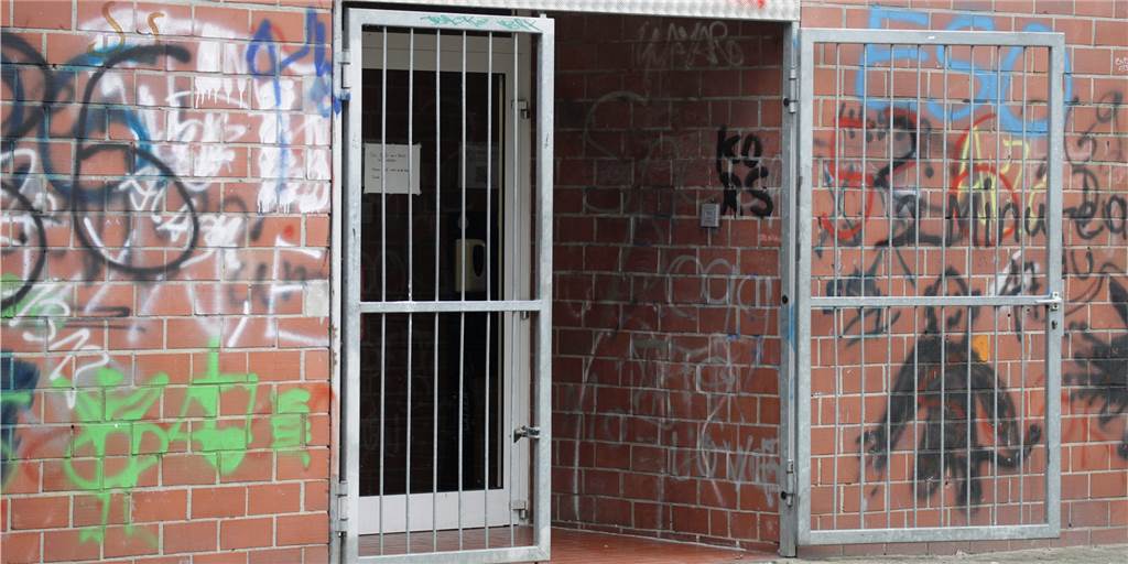 Dealer, Waffen, Randale: Turnhalle in Brambauer ein Problem-Treff? Schmierereien ziehen sich über die Fassade der Turnhalle. Der Eingang war sonst auch Treffpunkt der "Feiernden", das verhindert nun ein Gitter.