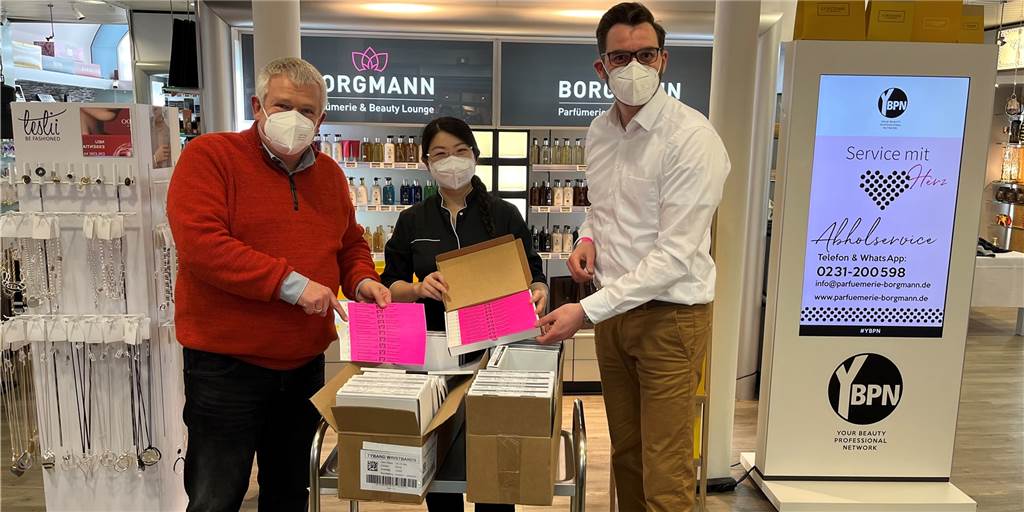 2G-Regel beim Shopping: Bunte Bändchen gelten jetzt in noch mehr Geschäften Umgehend kann das Bändchensystem für den Einzelhandel in ganz Dortmund Stadt starten. Wie hier in Brackel an Yuanyuan Tan verteilen Markus Kaluza (r.) vom Handelsverband und Andreas Eller (l.) vom Stadtbezirksmarketing die Bändchen an die interessierten Gewerbevereine.