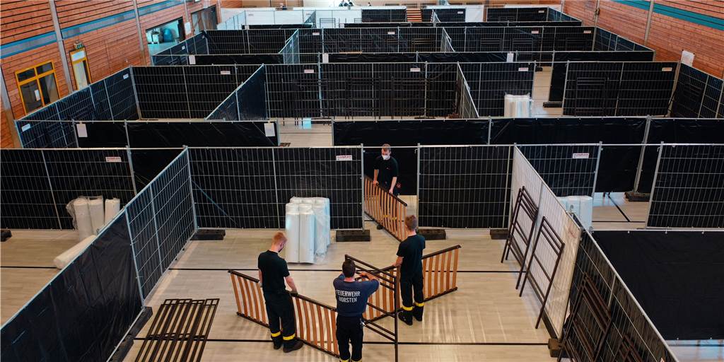Blick in eine Notunterkunft in Dorsten: Freiheit auf 27 Quadratmetern Blick in die Josefhalle in Dorsten. Feuerwehrleute helfen beim Aufbau der Notunterkunft.
