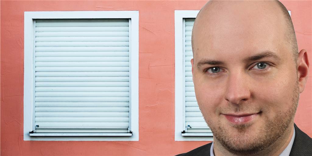Strategie gegen Wohnungsmangel? Timo Gätzschmann will Leerstandssteuer Timo Gätzschmann vor heruntergelassenen Rollläden an einem Haus