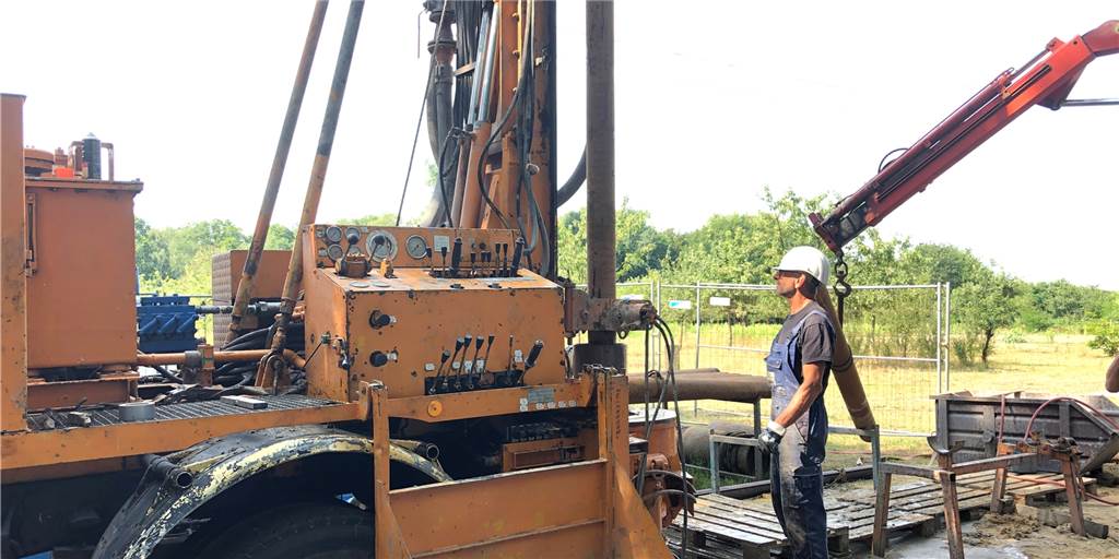 Ein Arbeiter steht neben Maschine, die in Schermbeck 2019 ein 100 Meter tiefes Loch bohrte.