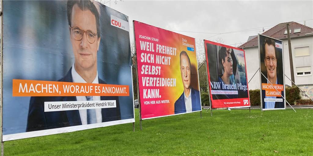 Vier Parteien pflastern den Engelsburgplatz mit Wahl-Großplakaten zu Man sieht, dass man am Engelsburgplatz nichts mehr sieht außer riesiger Wahlplakate zur Landtagswahl. Die stehen auf dem Platz in drei Reihen angeordnet.