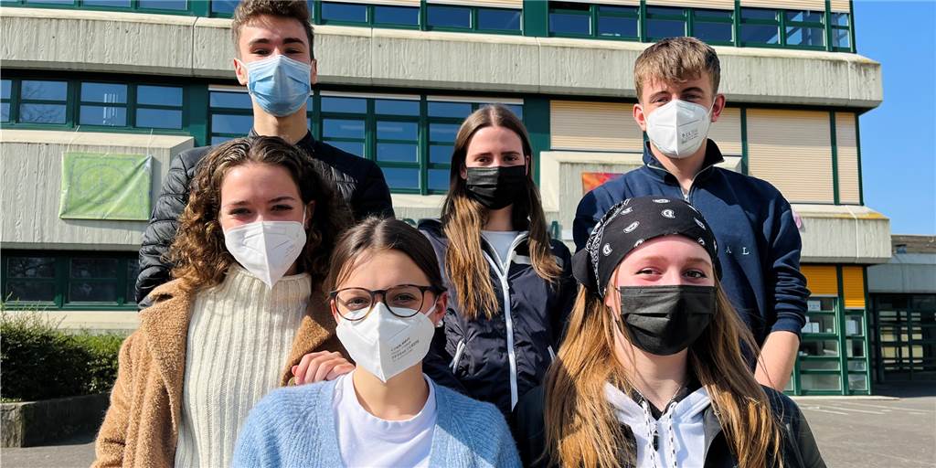 „Härtet ab, aber was kommt noch?“ - Wie Jugendliche in ihre Zukunft blicken Sechs Jugendliche stehen vor der Schule.