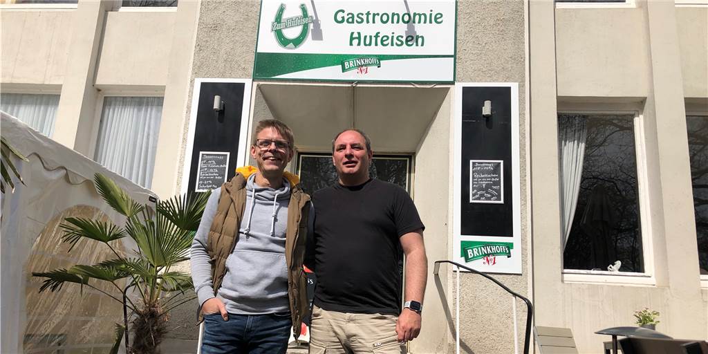 Kuriose Job-Anzeige: „Du kannst lächeln und die Uhr lesen?“ Andrew Carruthers und Matthias Hesse (v.l.) suchen mit ungewöhnlichen Mitteln neue Mitarbeiter für die Gastronomie "Hufeisen" auf dem Rennbahn-Gelände