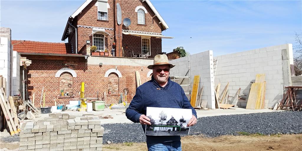 Zu wenig Wände für moderne Kunst: Lüner Galerie setzt auf neuen Anbau Galerist Wolfgang Anders - hier vor der Baustelle an der Galerie - mit einem Bild in den Händen, der zeigt, wie der Anbau aussehen wird.