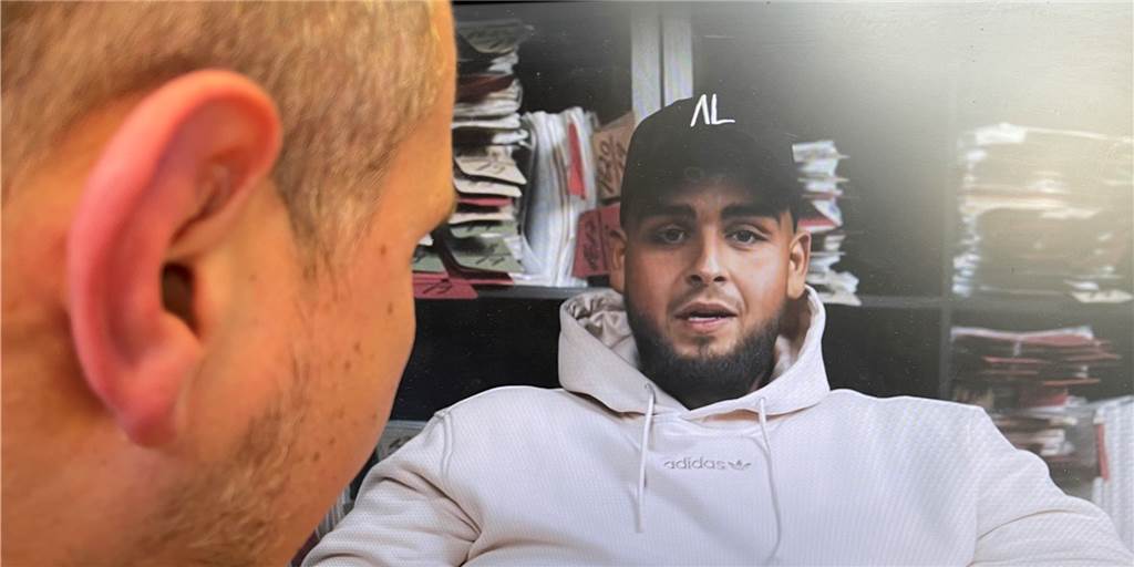 Ohrfeige für Pocher: „Fat Comedy“ überrascht mit Video mit bekanntem Anwalt Ein Standbild des Youtube-Videos von "Fat Comedy" ist auf einem Monitor zu sehen, davor angeschnitten der Kopf eines Mannes.