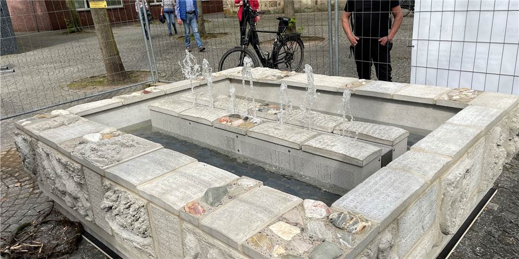 Beliebter Tisa-Brunnen wieder in Dorsten zurück: Nachbau eingeschwebt Sprudelnder Brunnen mit Passanten.