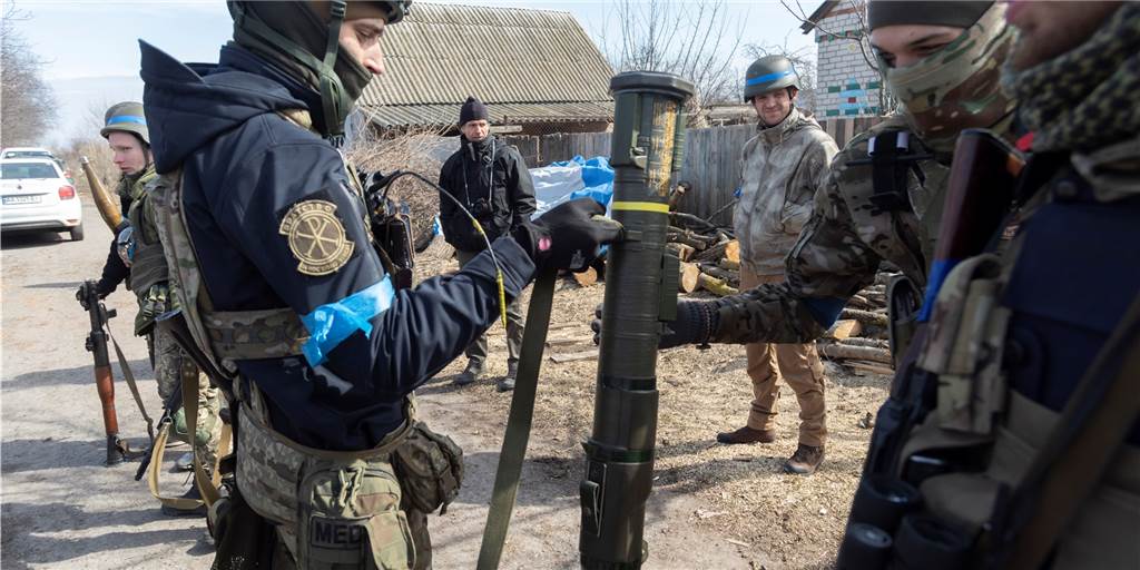Weltweite Waffenflut in die Ukraine: Wie wird überwacht, wo die Waffen am Ende landen? Zwei Ukrainische Soldaten halten eine Panzerfaust, während weitere die Szene beobachten.