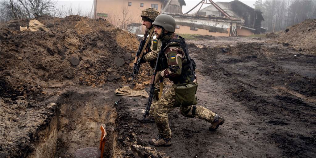 Russen greifen Dorf um Dorf an: Kann Putin noch einen schnellen Sieg erzwingen? Ukrainische Soldaten nähern sich einem Graben, den russische Soldaten bei der Rückeroberung eines Gebiets am Stadtrand von Kiew benutzt hatten.