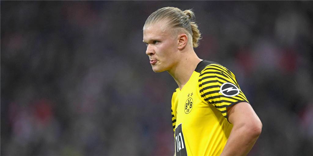 Weiterer Trip an die Côte d’Azur: Erling Haaland lässt den BVB zappeln BVB-Stürmer Erling Haaland hat die Hände in die Hüfte gestemmt und blickt konzentriert nach links.