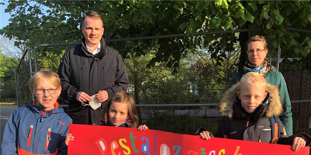 Die Schülerinnen und Schüler der Pestalozzischule wünschen sich mehr Spielgeräte auf dem Schulhof und, dass der Bauzaun vom Schulgelände verschwindet. Der Klassensprecherrat hat dazu einen Brief geschrieben, der am Mittwoch, aufgeklebt auf einem großen Plakat, an Bürgermeister Tobias Stockhoff übergeben wurde.