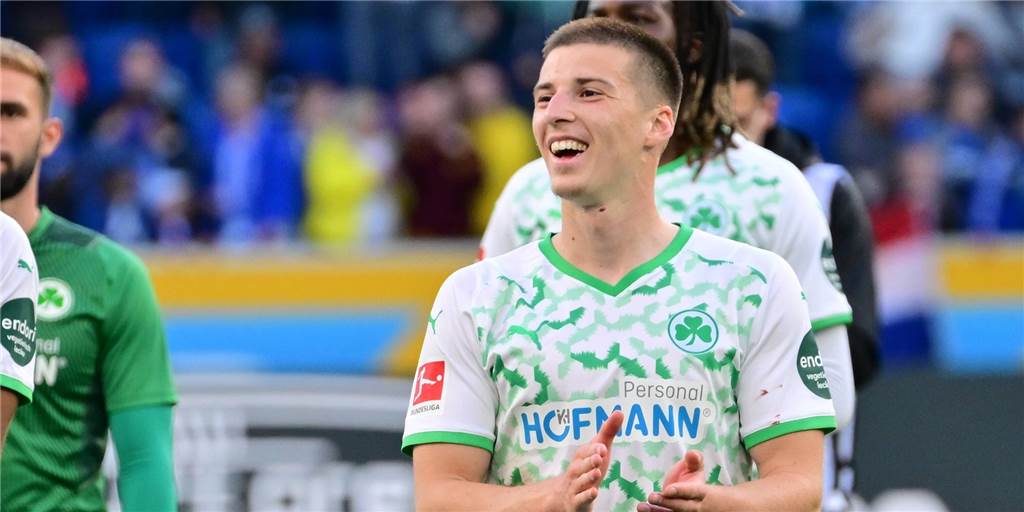 Tobias Raschl klatscht lächelnd in die Hände.