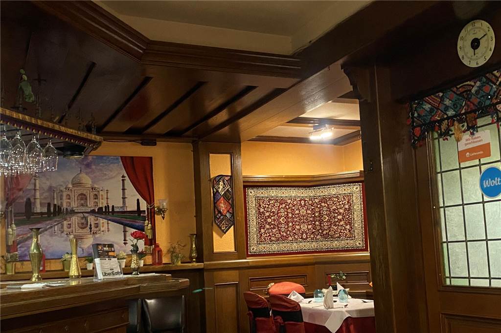 „Tandoori Love“ im Restaurant-Check der Ruhr Nachrichten: Ein Blick in „Tandoori Love” mit einem Bild vom Taj Mahal und einem Teppich an der Wand