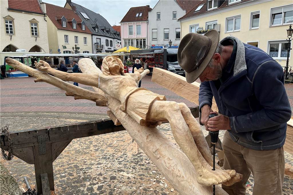 Bildhauer Ernst Franz bohrt die Löcher in die Füße der Christus-Figur