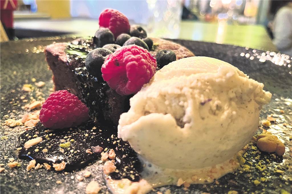 Chocolate-Peanut-Brownie mit Vanilleeis und Beeren.