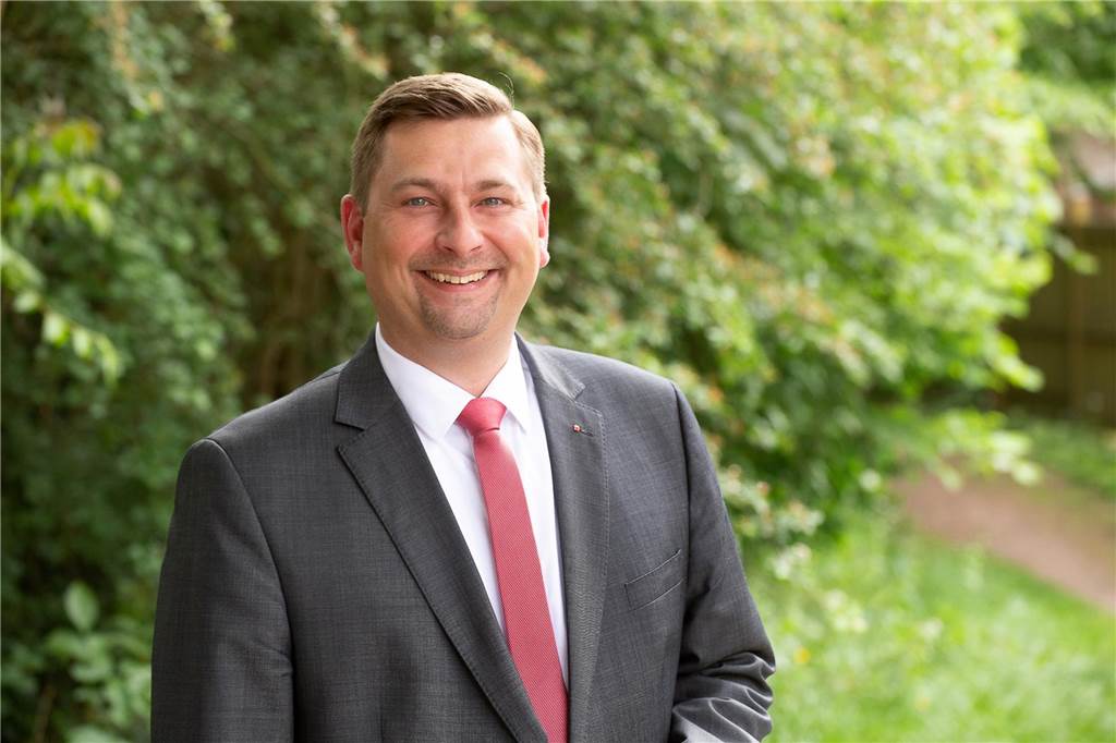 Haftprüfungstermin: Daniel Wolski bleibt in U-Haft - Anklage erhoben Pressefoto von Daniel Wolski: Er trägt einen Anzug und lacht in die Kamera.