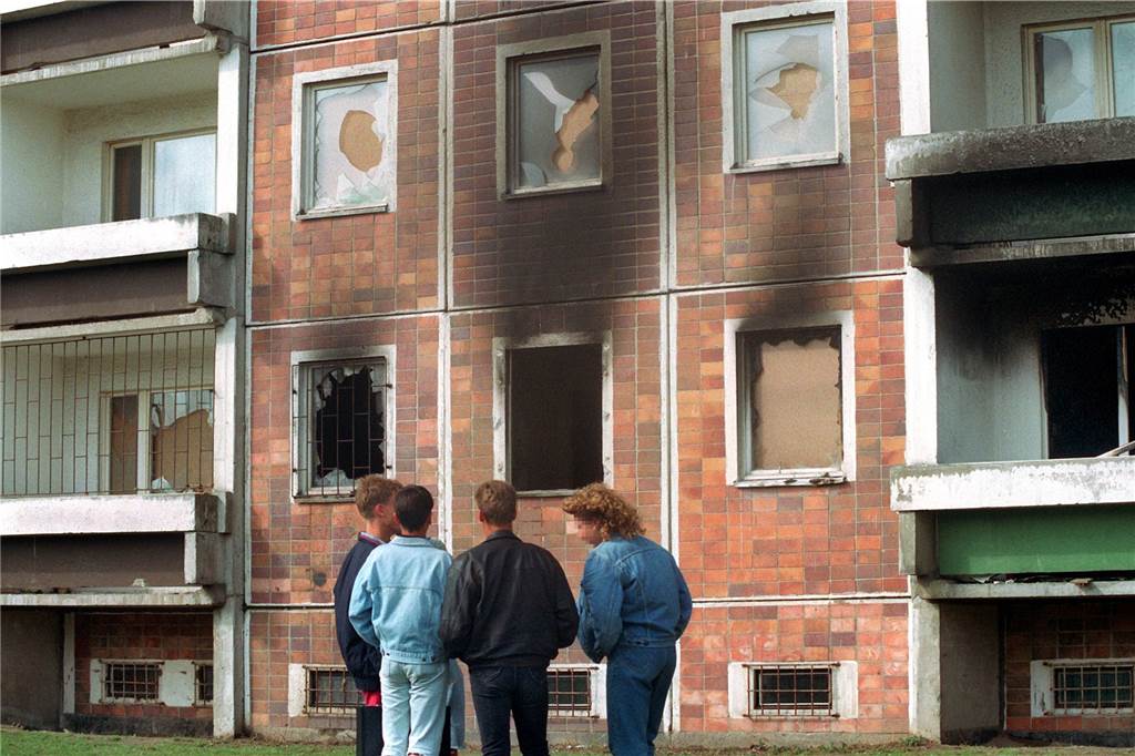30 Jahre Rostock-Lichtenhagen: „Sowas kann jederzeit wieder passieren, in jeder Stadt“ Blick auf das von über 100 Vietnamesen bewohnte Haus neben dem Asylbewerberheim am 25. August 1992, das am Vortag von ausländerfeindlichen Randalierern in Brand gesetzt wurde.