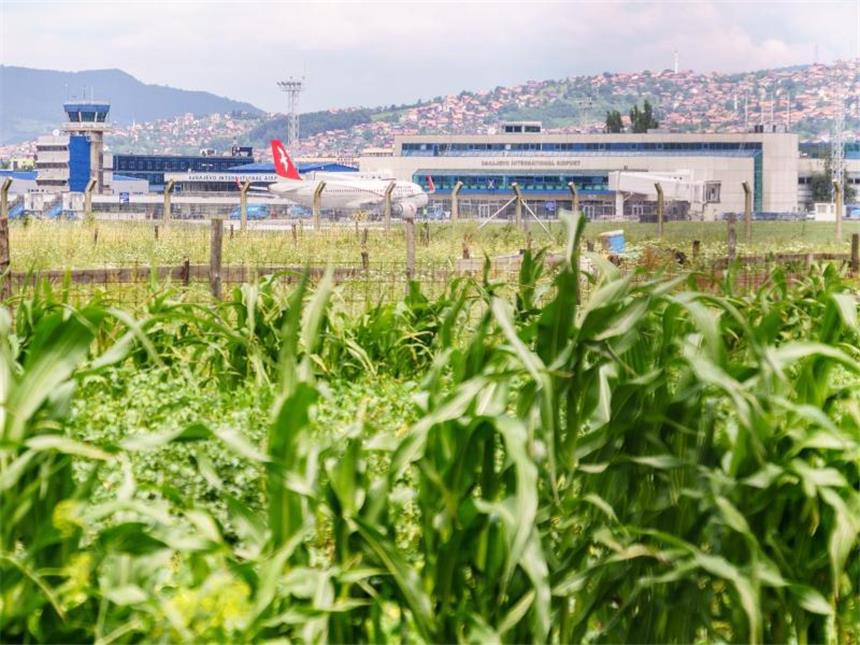 Erinnerung an den Krieg: Sarajevos "Tunnel des Lebens" Blick hinüber zum Flughafen von Sarajevo: Während der Belagerung der Stadt im Bosnienkrieg übernahmen die Vereinten Nationen das Gelände - der Tunnel führte unter dem Flugfeld hindurch. Foto: Philipp Laage/dpa-tmn