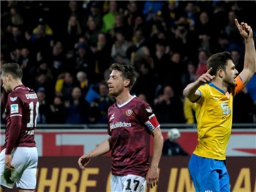 Braunschweigs Ken Reichel (r) bejubelt seinen Treffer zum 1:0 gegen Dynamo Dresden, während sich die Dynamo-Spieler Jannik Müller (l) und Andreas Lambertz wegdrehen. Foto: Peter Steffen