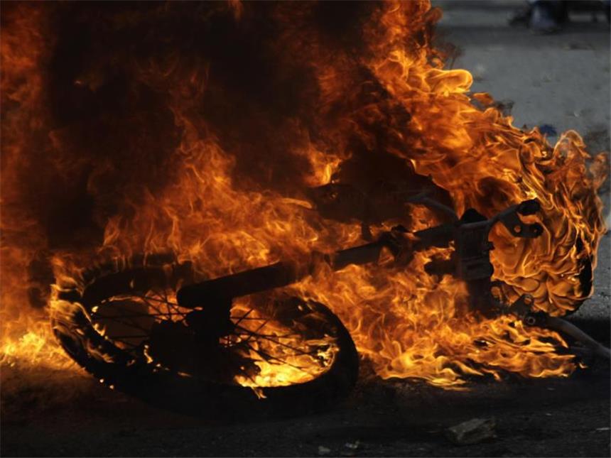 Blutige Proteste gegen die Regierung in Venezuela Brennendes Motorrad: Präsident Maduro spricht von einer Verschwörung der Opposition. Foto: Fernando Llanos