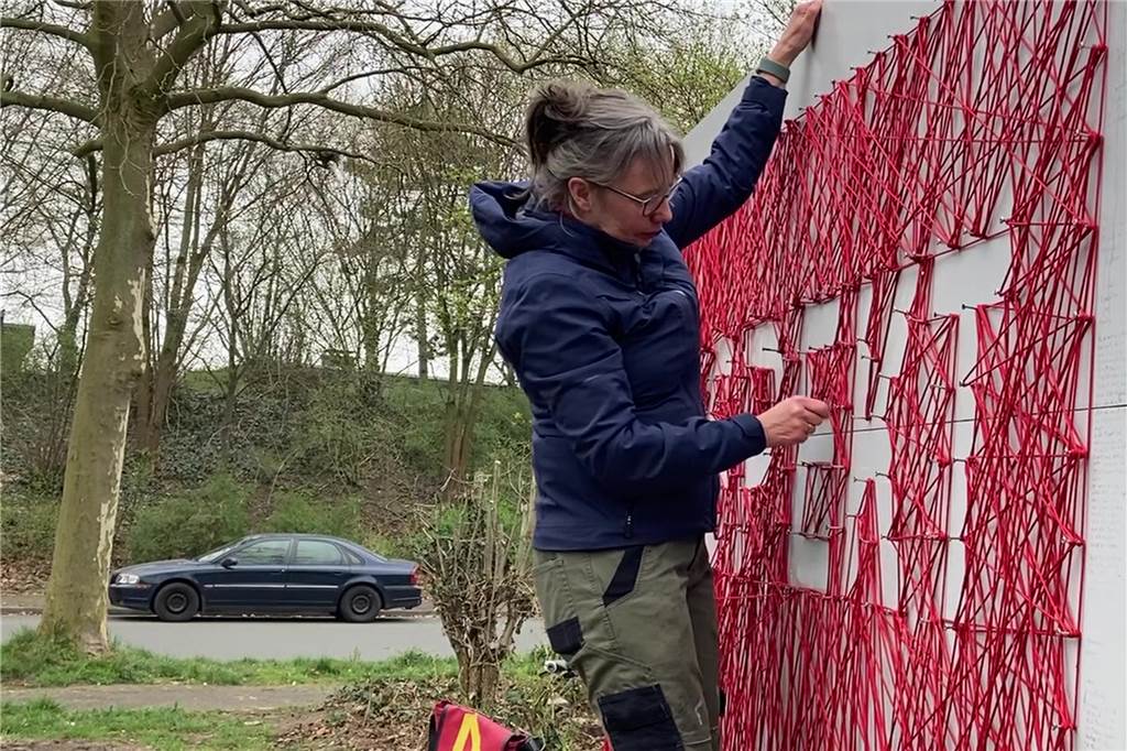Respekt: Brigitte Stüwe zieht alle Fäden am Dorstener Kunstwerk neu (mit Video) Brigitte Stüwe zieht die roten Fäden rund um die Buchstaben-Schablonen.