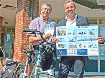 Broschüren, Handbücher und Poster in Deutsch, Englisch und Arabisch übergab Berthold Enning (l.), Schermbecker Bereichsleiter der Verkehrswacht Wesel, am Freitag an Bürgermeister Mike Rexforth. Verteilt wird das Infomaterial an Flüchtlinge der Gemeinde, die so die Grundregeln für Radfahrer im Straßenverkehr erlernen sollen.