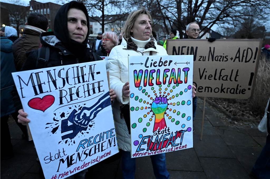 Bürger stehen mit Schildern vor dem Saalbau in Witten und demonstrieren gegen Rechtsextremismus.