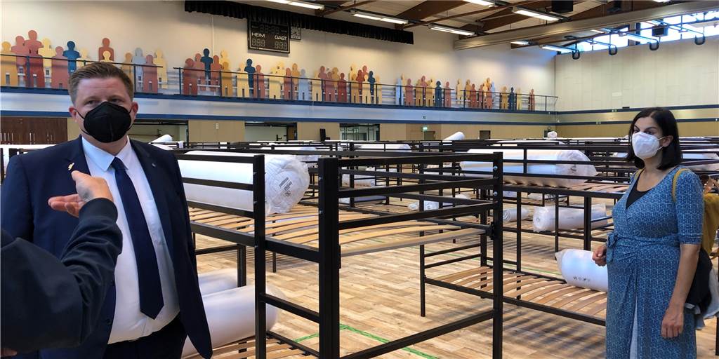 Seestadthalle: Wo sonst Sportler trainieren, stehen jetzt Doppelstockbetten Bürgermeister Andreas Stegemann und Sarah Radas in der Seestadthalle