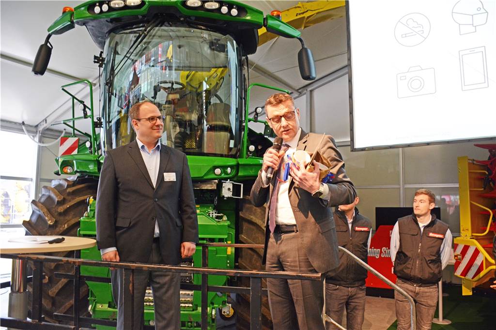 Kempers „Kolbenfresser“ ernten 500 Tonnen Mais in der Stunde Bürgermeister Berthold Dittmann überreicht Gastgeber Benjamin, Geschäftsführer der Maschinenfabrik Kemper, ein Geschenk.