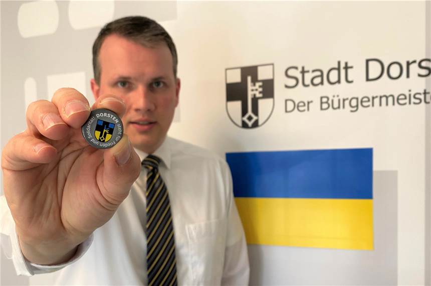 Dorsten-Ukraine-Buttons gegen eine Spende in der Stadtinfo erhältlich Bürgermeister Tobias Stockhoff zeigt den Dorsten-Ukraine-Button, der seit Dienstag in der Stadtinfo erhältlich ist.