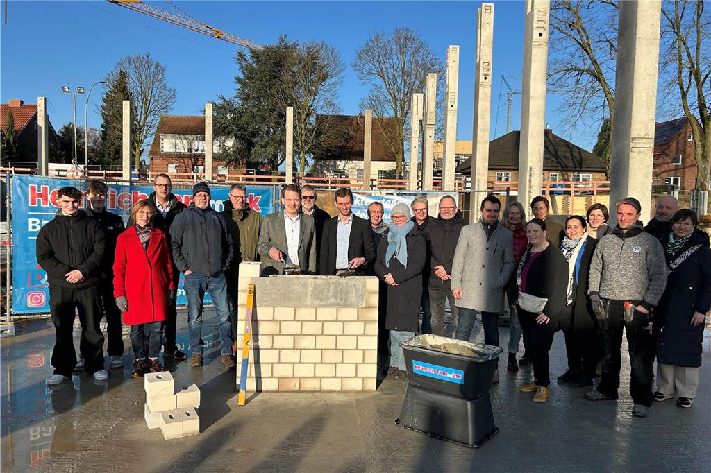 Grundsteinlegung: Zeitkapsel in Fundament der Dreifachhalle eingemauert Männer und Frauen auf einer Baustelle