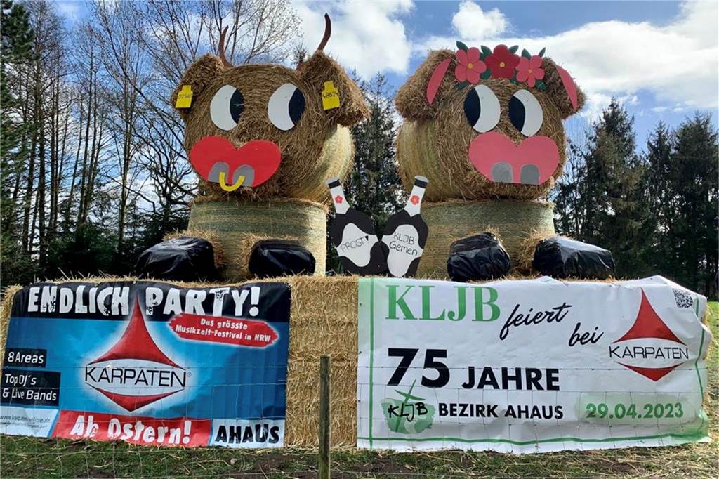 Bulle und Kuh prosten sich in Gemen zu. Dort hat die KLJB die Figuren an der Straße aufgestellt und freut sich auf die Jubiläumsfeier.