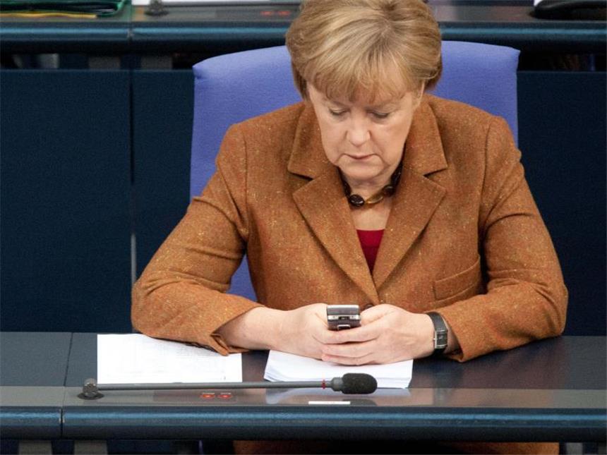 Zugriff von Polizei auf Handydaten neu geregelt Bundeskanzlerin Angela Merkel beschäftigt sich im Bundestag mit ihrem Smartphone. Foto: Maurizio Gambarini/Archiv