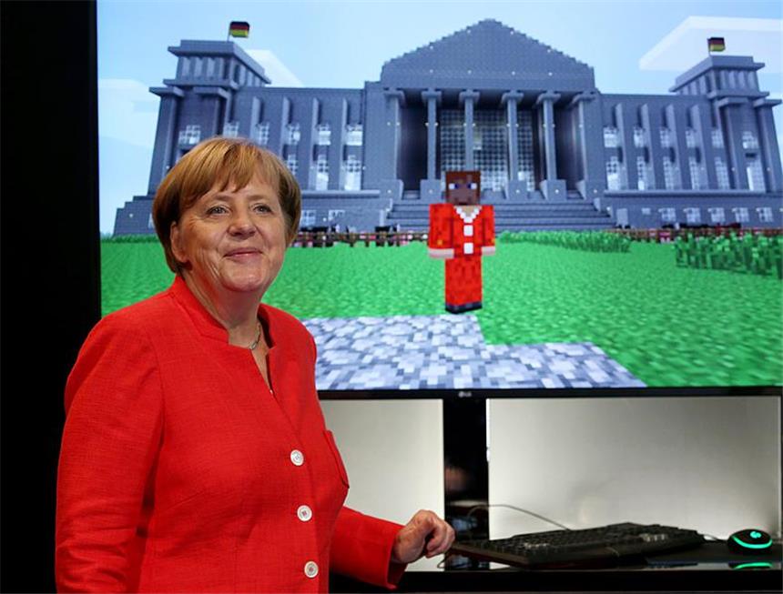 Bundeskanzlerin Angela Merkel (CDU) steht am 22.08.2017 in Köln (Nordrhein-Westfalen) vor einem Computerbildschirm, auf dem sie selbst vor dem Reichstagsgebäude dargestellt ist. Bundeskanzlerin Angela Merkel eröffnet die Computerspielemesse Gamescom (22. bis 26.08.2017). Foto: Oliver Berg/dpa +++(c) dpa - Bildfunk+++
