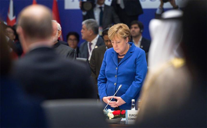 Einigung auf Friedensverhandlungen für Syrien Bundeskanzlerin Angela Merkel (CDU) steht am beim Gipfel der großen Industrie- und Schwellenländer (G20) in Belek bei Antalya (Türkei) zu Beginn der Sitzung bei einer Schweigeminute für die Opfer der Terroranschläge in Paris an ihrem Platz.