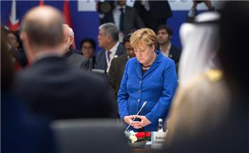 Bundeskanzlerin Angela Merkel (CDU) steht am beim Gipfel der großen Industrie- und Schwellenländer (G20) in Belek bei Antalya (Türkei) zu Beginn der Sitzung bei einer Schweigeminute für die Opfer der Terroranschläge in Paris an ihrem Platz. 