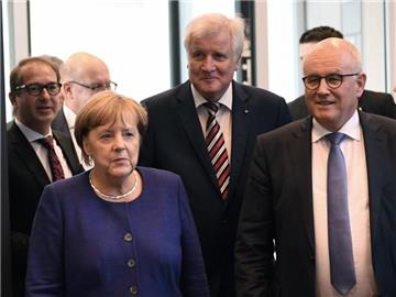 Bundeskanzlerin Angela Merkel (CDU) trifft in Berlin zu einer Fraktionssitzung der CDU mit dem bayerischen Ministerpräsidenten Horst Seehofer (CSU, M) ein. Foto: Ralf Hirschberger
