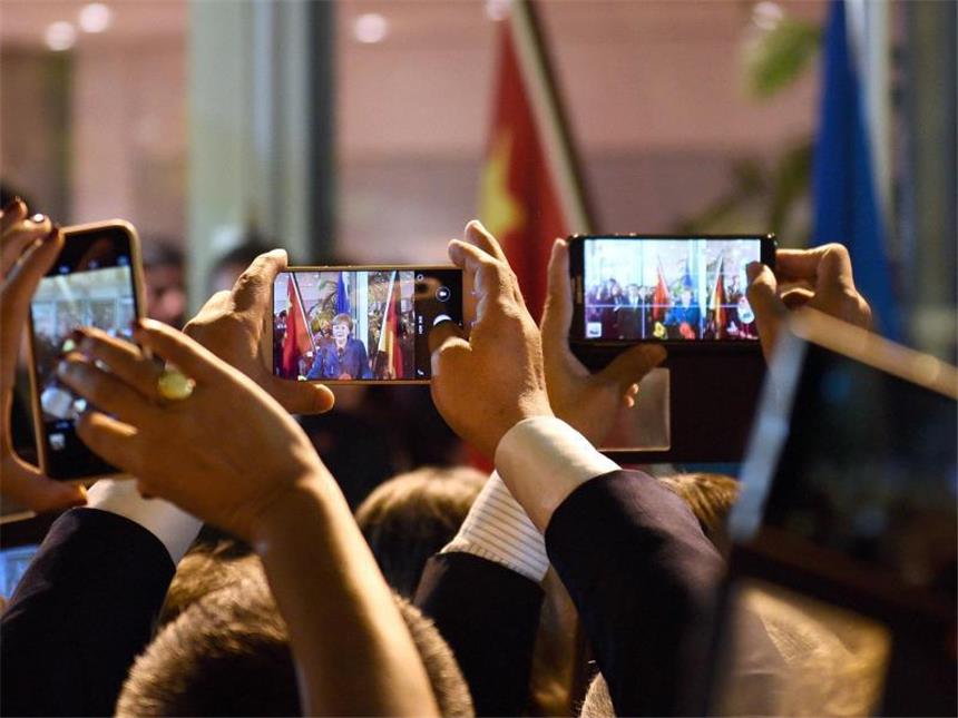 Experten erwarten härtere Kämpfe um Hightech-Metalle Bundeskanzlerin Angela Merkel wird mit Smartphones fotografiert und gefilmt. Foto: Rainer Jensen/Archiv