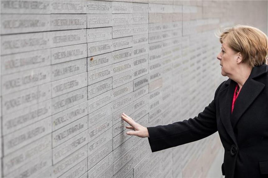 Journalistin scheitert mit Klage gegen Verfassungsschutz Bundeskanzlerin Merkel (CDU) berührt in Buenos Aires (Argentinien) die Wand mit den Namen der Opfer der Diktatur zwischen 1976 und 1983. Foto: Michael Kappeler/Archiv