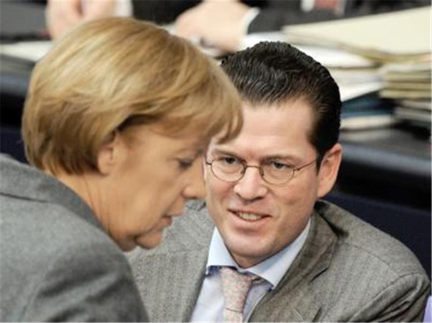 Bundeskanzlerin Merkel und Verteidigungsminister zu Guttenberg (CSU) unterhalten sich im Bundestag. Guttenberg steht wegen der Kundus-Affäre verschärft in der Kritik.