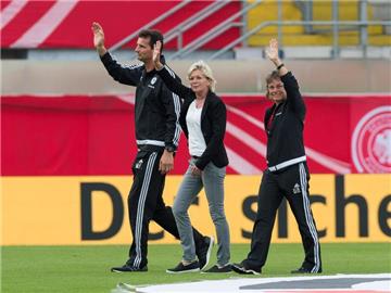 Bundestrainerin Silvia Neid (M) und ihr Trainerteam bedanken sich bei den Fans. Foto: Guido Kirchner