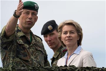 Bundesverteidigungsministerin Ursula von der Leyen steht auf einem Truppenübungsplatz neben Brigadegeneral Heico Hübner und wartet auf den Beginn eines Manövers. Am Tag der Bundeswehr präsentieren sich die deutschen Streitkräfte. Foto: Bernd Thissen/Archiv