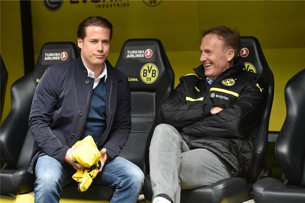 Lars Ricken und Hans-Joachim Watzke sitzen auf der Ersatzbank.