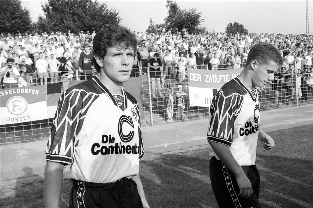 Lars Ricken und Andreas Möller gehen über den Rasen.