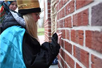 Carla schreibt den Spruch an eine Hauswand.